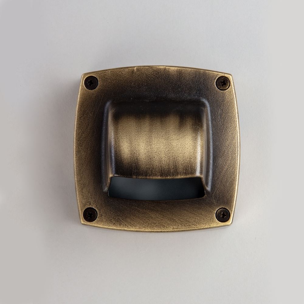 An Old School Electric square brass door handle on a white surface with lighting fixtures.