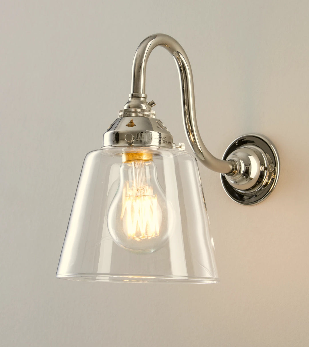 A wall light with a glass shade and a light bulb.