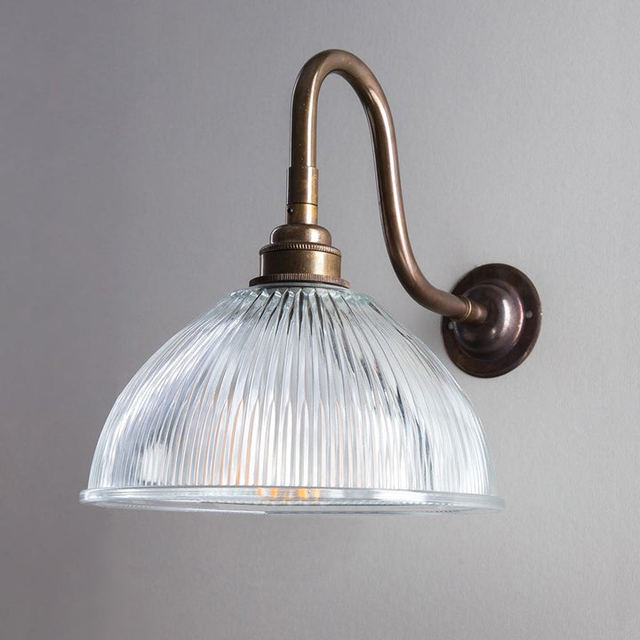 An Old School Electric Prismatic Dome Swan Arm Wall Light with a glass shade.