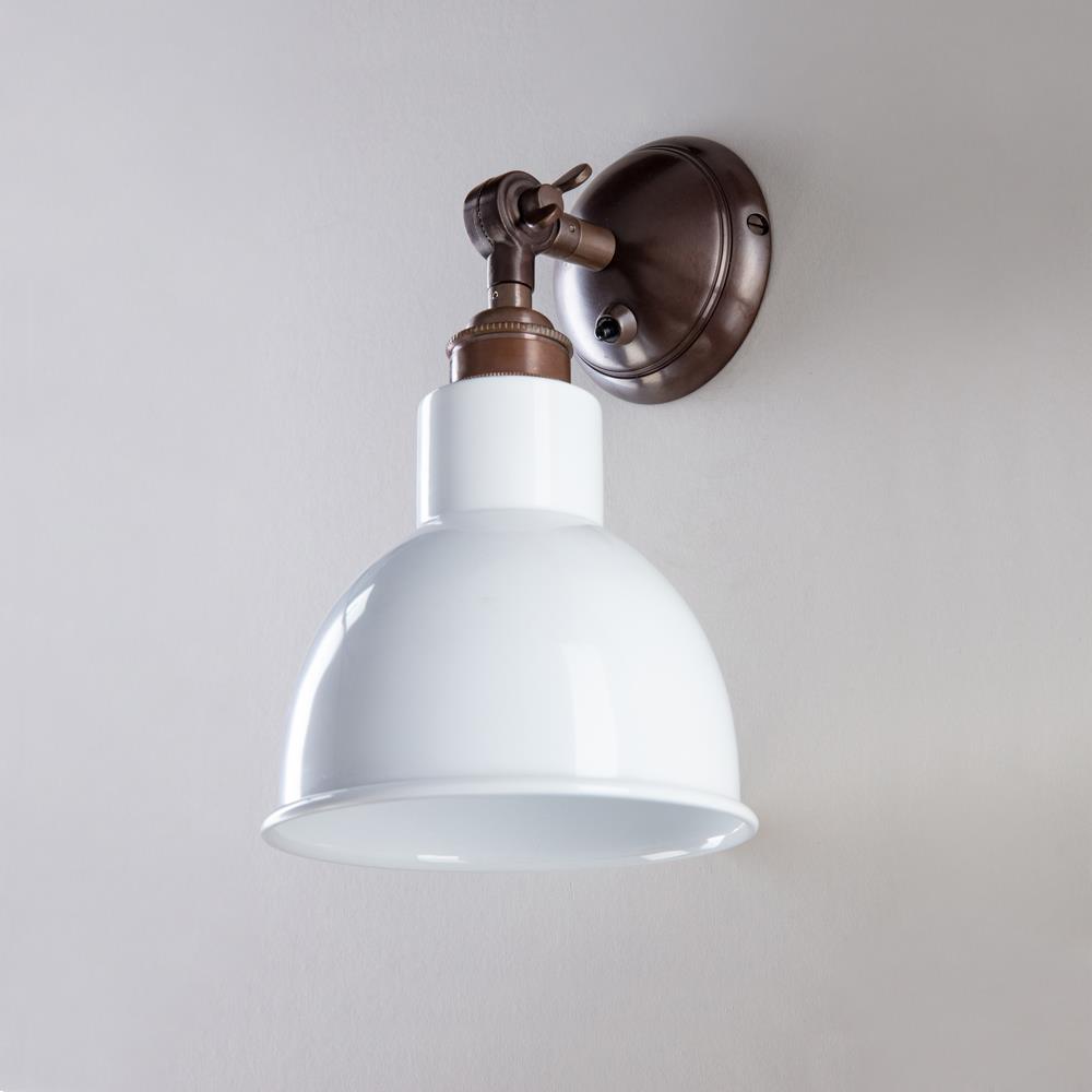 An Churchill Short Arm Wall Light fixture by Old School Electric on a white wall.