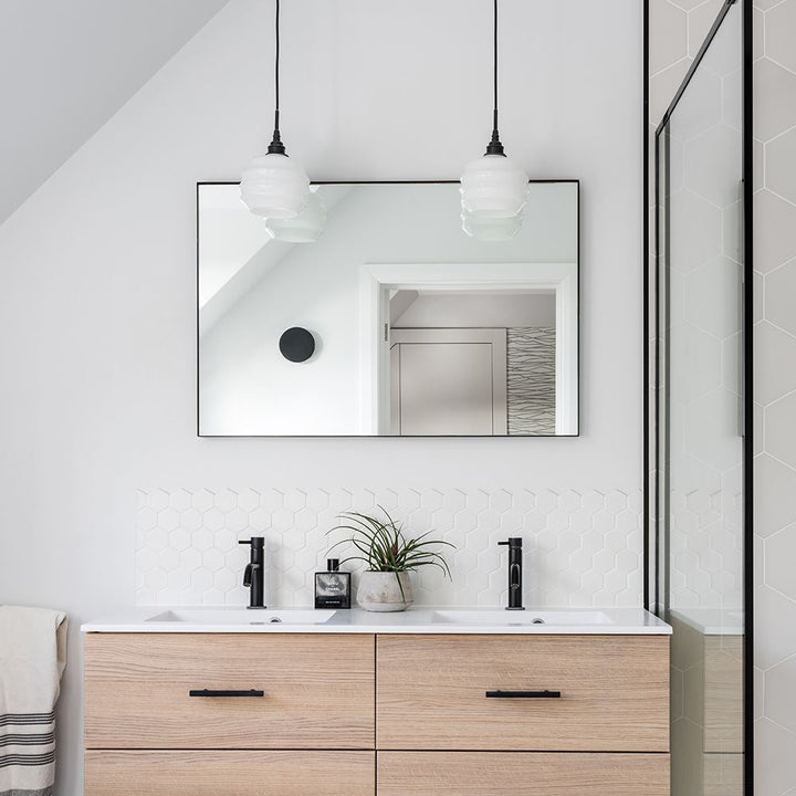 A modern bathroom with a Deco Opal Glass Pendant vanity and mirror by Old School Electric featuring timeless elegance.