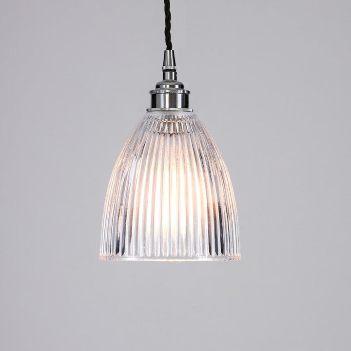 An Elongated Prismatic Pendant Light from Old School Electric, a glass lighting fixture, hangs from the ceiling.