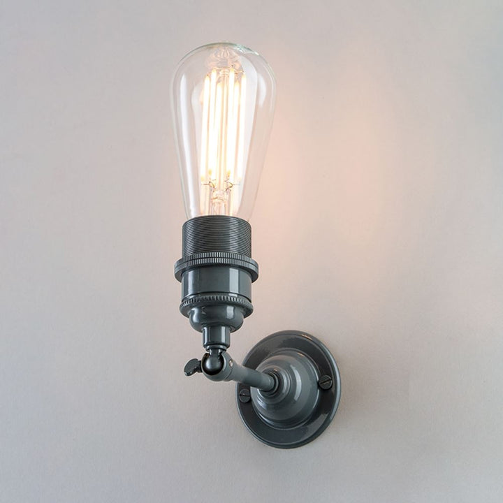 An Old School Electric Industrial Wall Light fitting with a bulb on it.