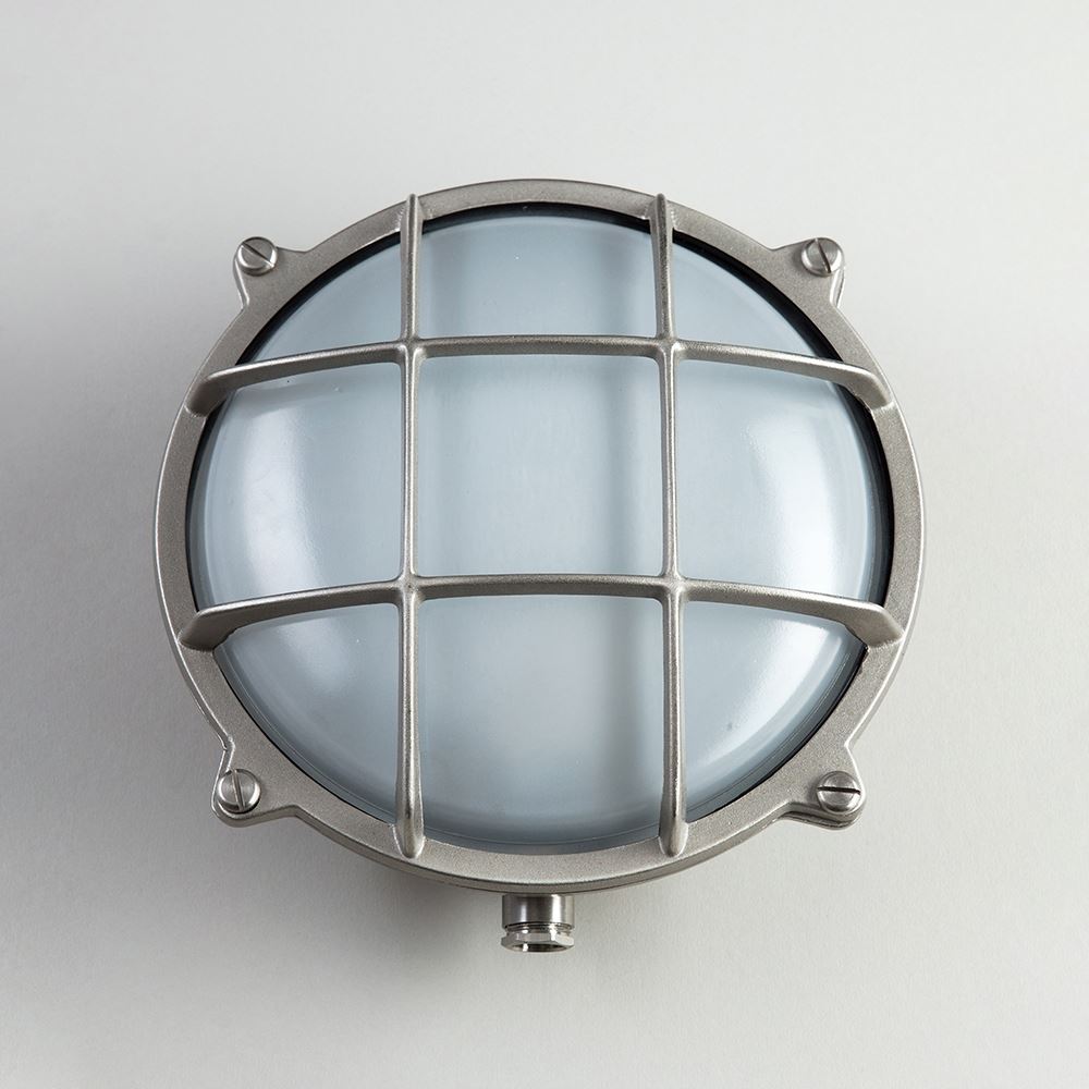 An outdoor Round Bulkhead Light fixture with a round glass shade from Old School Electric.