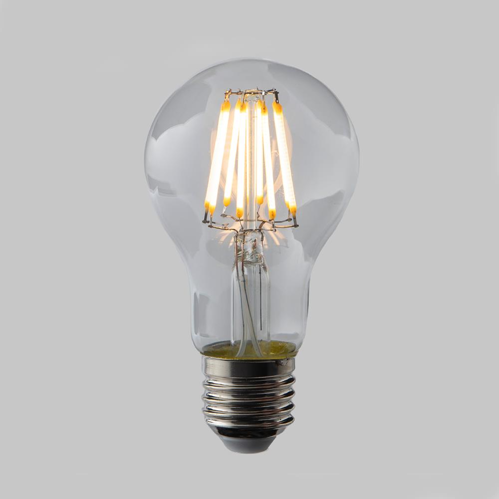 A clear LED Filament Dimmable GLS (E27) light bulb by Old School Electric shining brightly on a gray background.