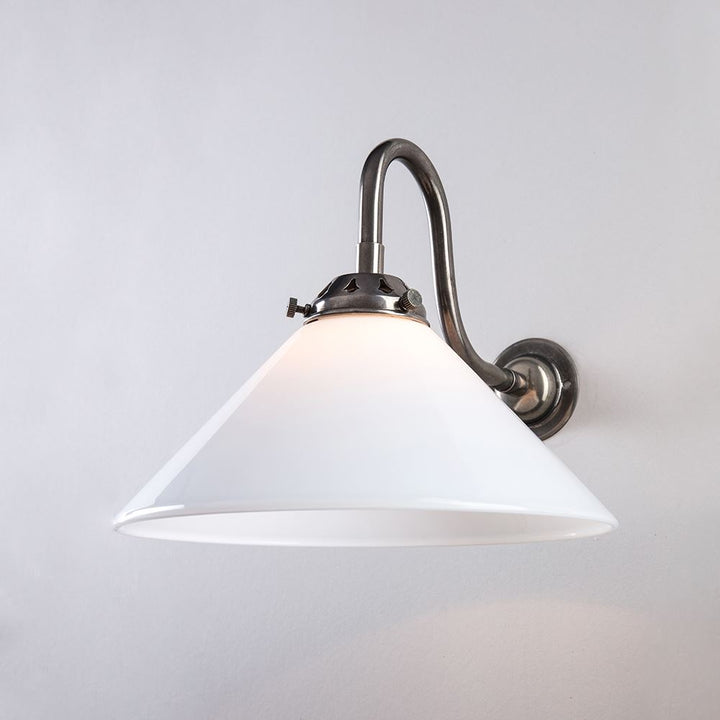An Old School Electric Conical Glass Bathroom Wall Light (B22) with a white shade on a white wall.
