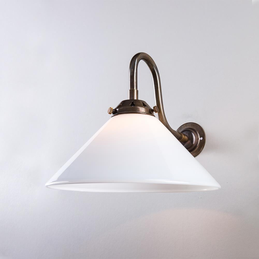 An Old School Electric Conical Glass Bathroom Wall Light (B22) with a white shade on a white wall.