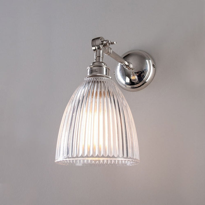 An Elongated Prismatic Adjustable Arm Wall Light from Old School Electric, with a clear glass shade, perfect for lighting fixtures and as a light fitting.