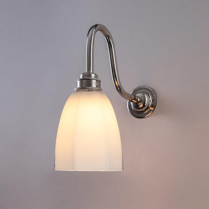 An Old School Electric Hexagon Bathroom Swan Wall Light with a white glass shade.