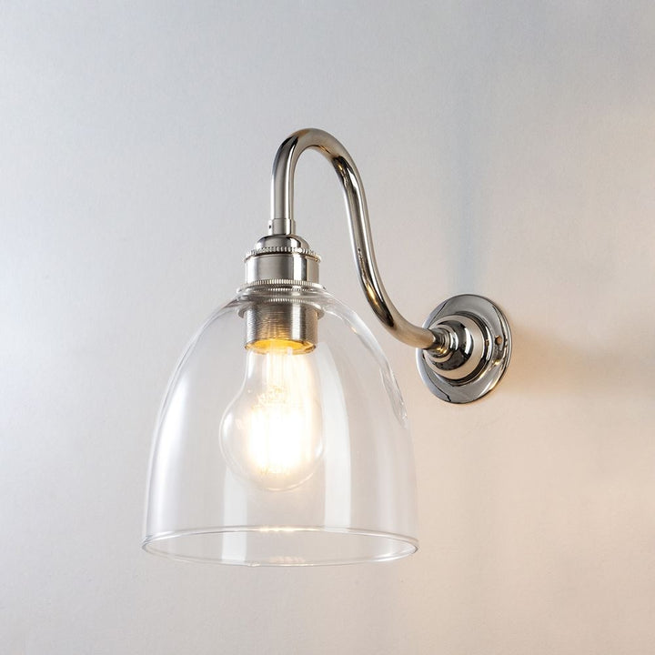 An Old School Electric Glass Swan Arm Wall Light with a clear glass shade, perfect for illuminating any space.