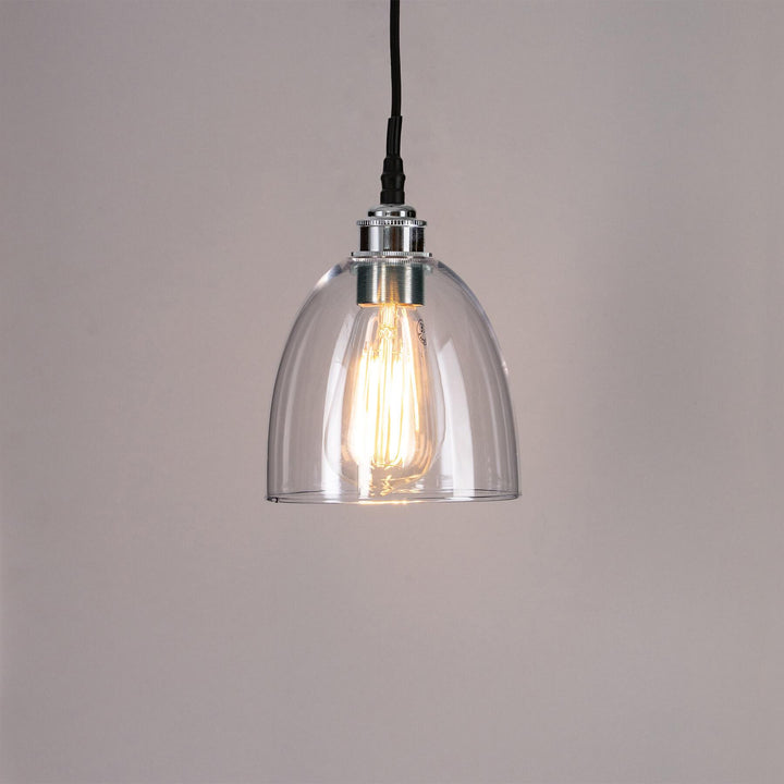 This Old School Electric Bell Blown Glass Bathroom Pendant Light features a clear glass shade and is suspended by a black cord. Perfect for adding a touch of stylish illumination to any bathroom.