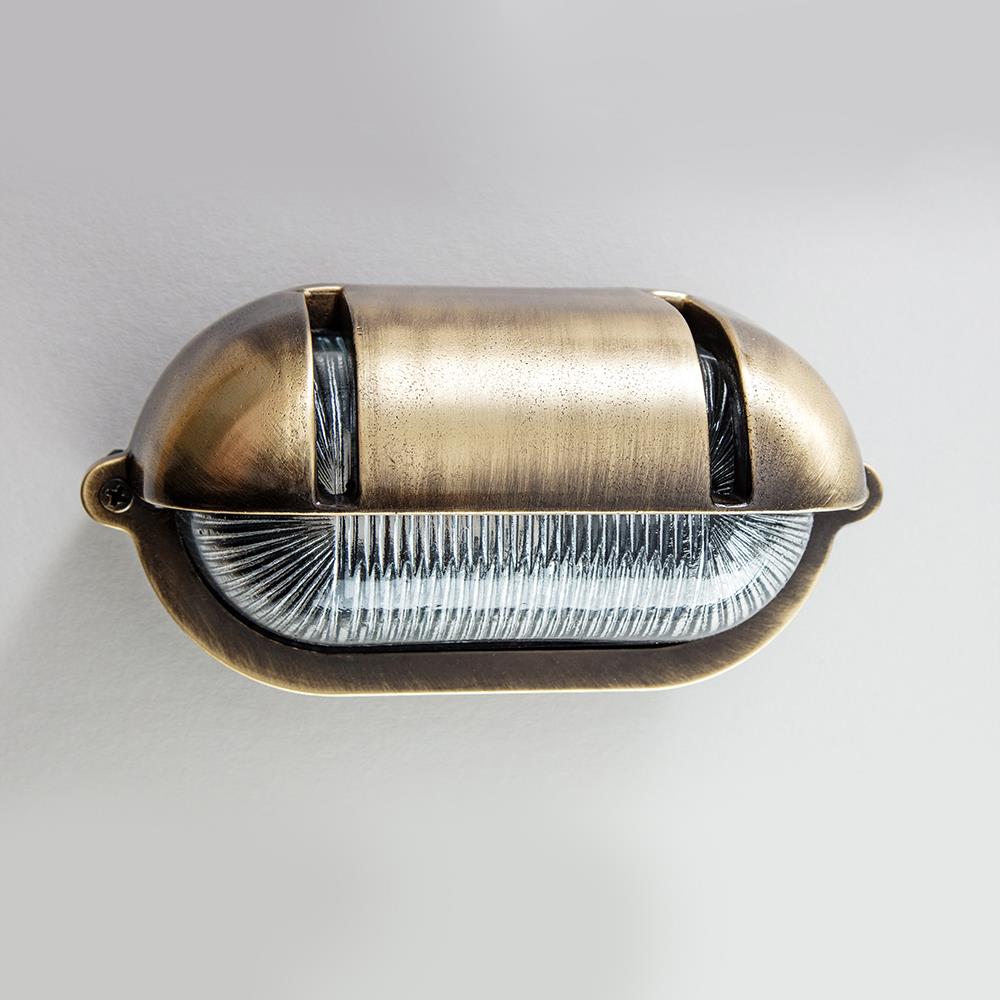 An Oval Bulkhead With Eyelid Wall Light by Old School Electric on a white wall.