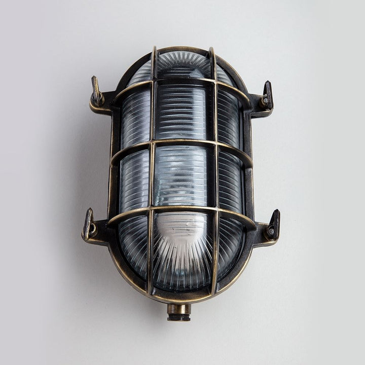 An electric Oval Bulkhead wall light with a glass shade, perfect for your lighting fixtures needs.
