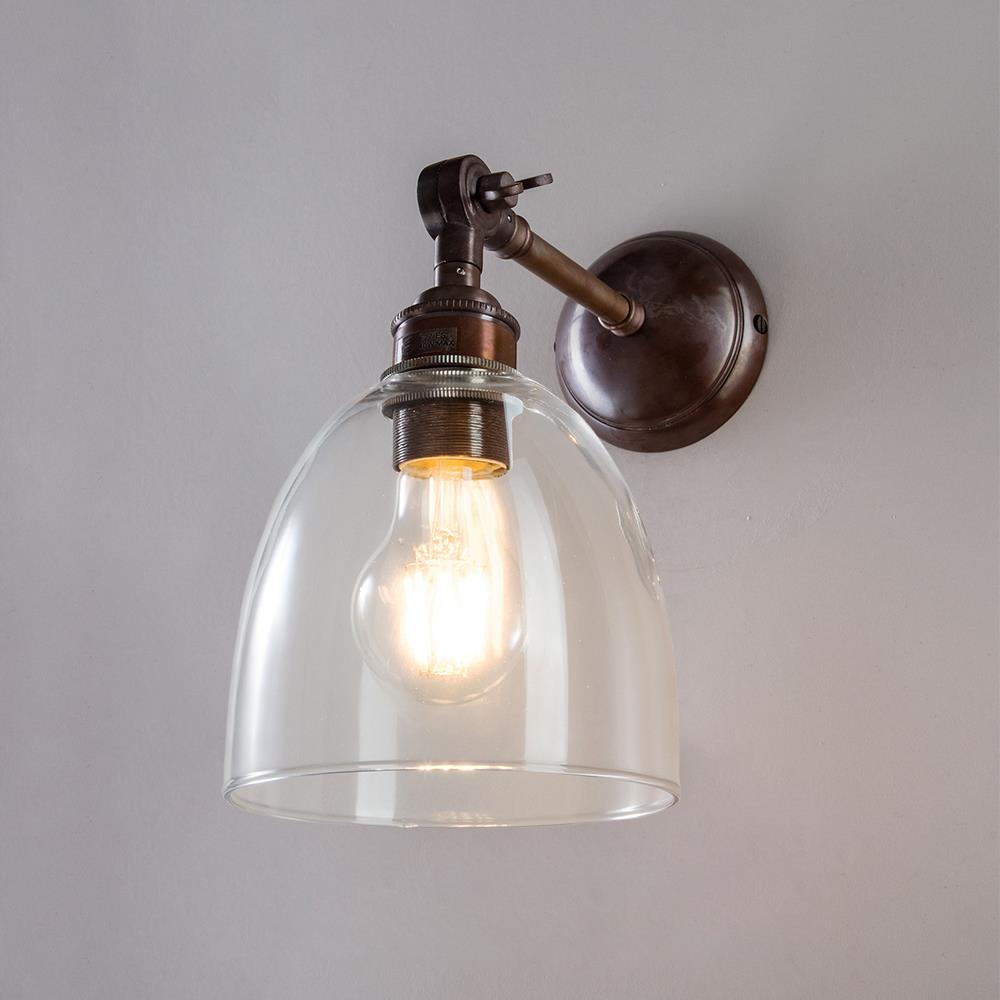 An Old School Electric Glass Adjustable Arm Wall Light fixture with a glass dome.