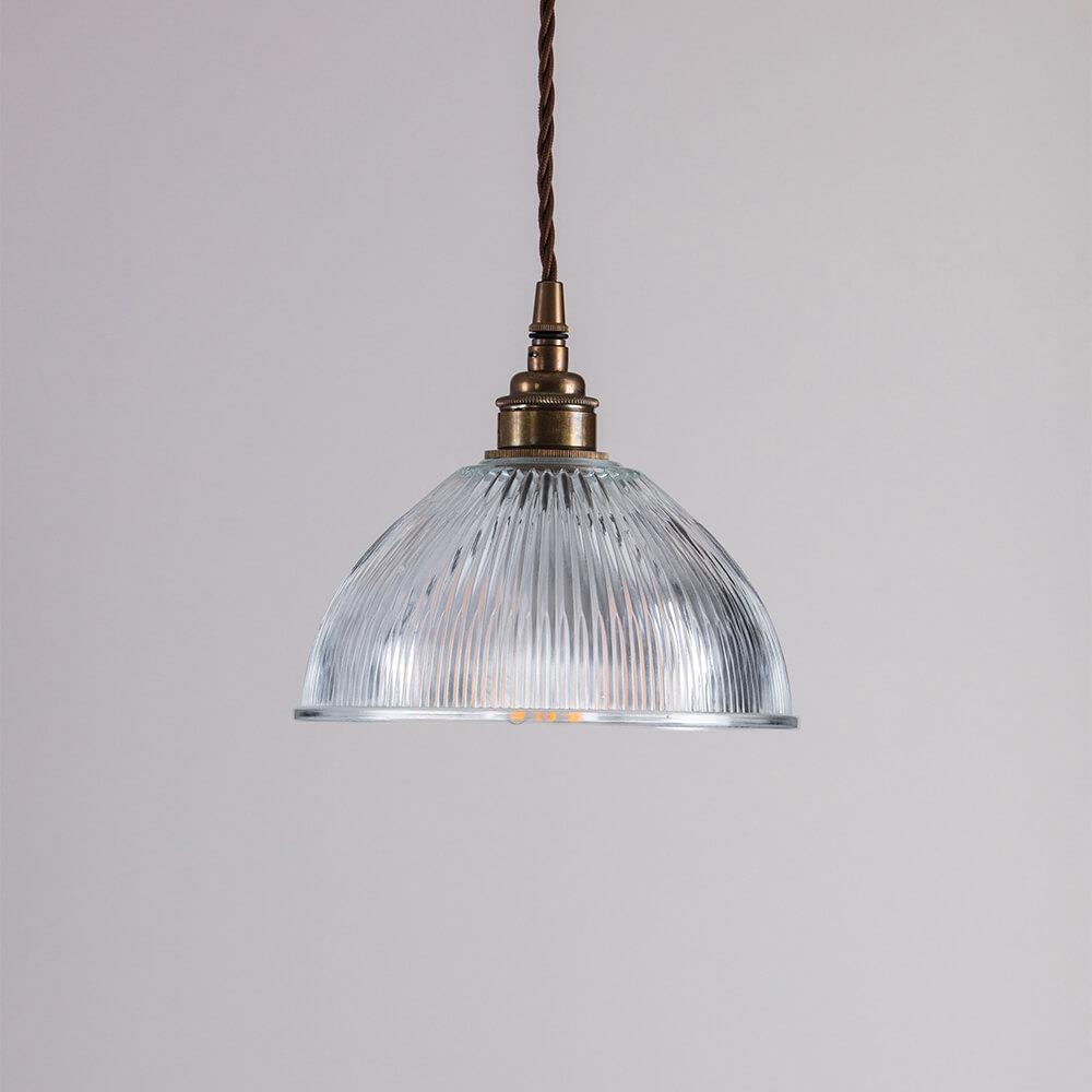 An Old School Electric Prismatic Dome Pendant Light fitting hanging from a brass chain.