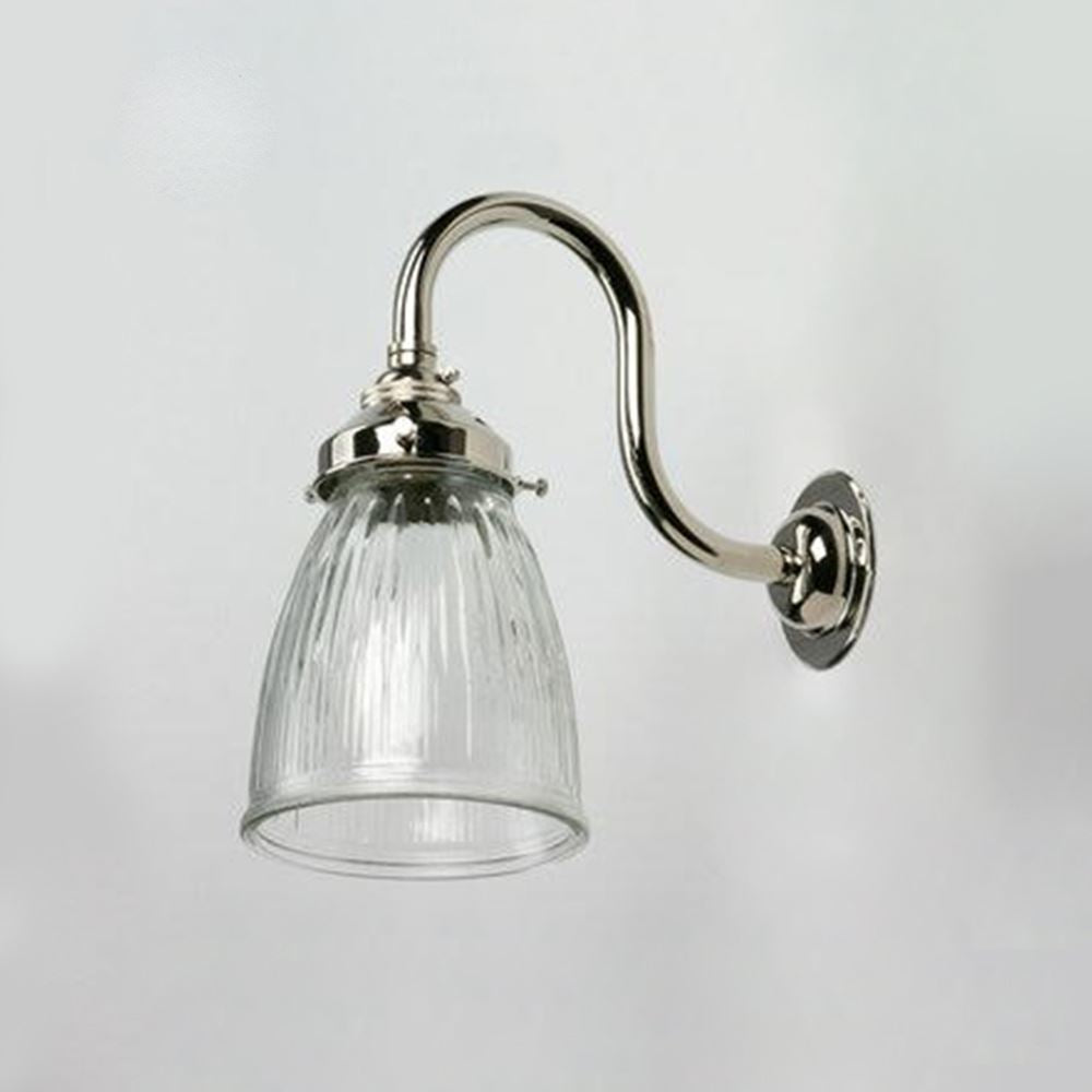 An Old School Electric Prismatic Snowdrop Wall Light with a glass shade on a white wall.