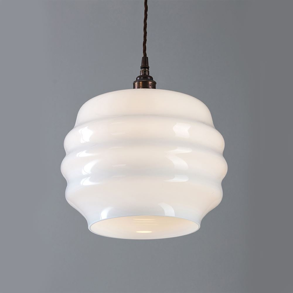 An Old School Electric Deco Opal Glass Pendant, also known as a light fitting, hanging on a grey wall.