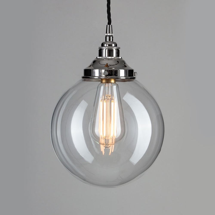 An Old School Electric Globe Blown Glass Pendant Light with a metal chain is a stunning example of lighting fixtures. This unique light fitting combines the elegance of clear glass with the durability of a metal chain. Perfect for any space.