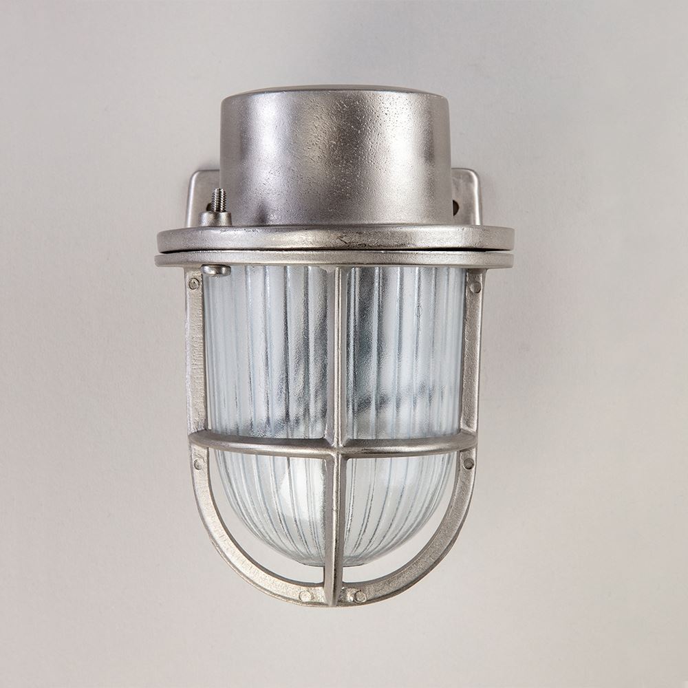 An Old School Electric Faros Mini Yacht Wall Light with a cage on it.