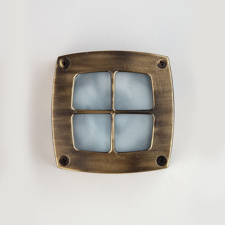 An Old School Electric square outdoor path light featuring a square brass light with a blue glass shade.