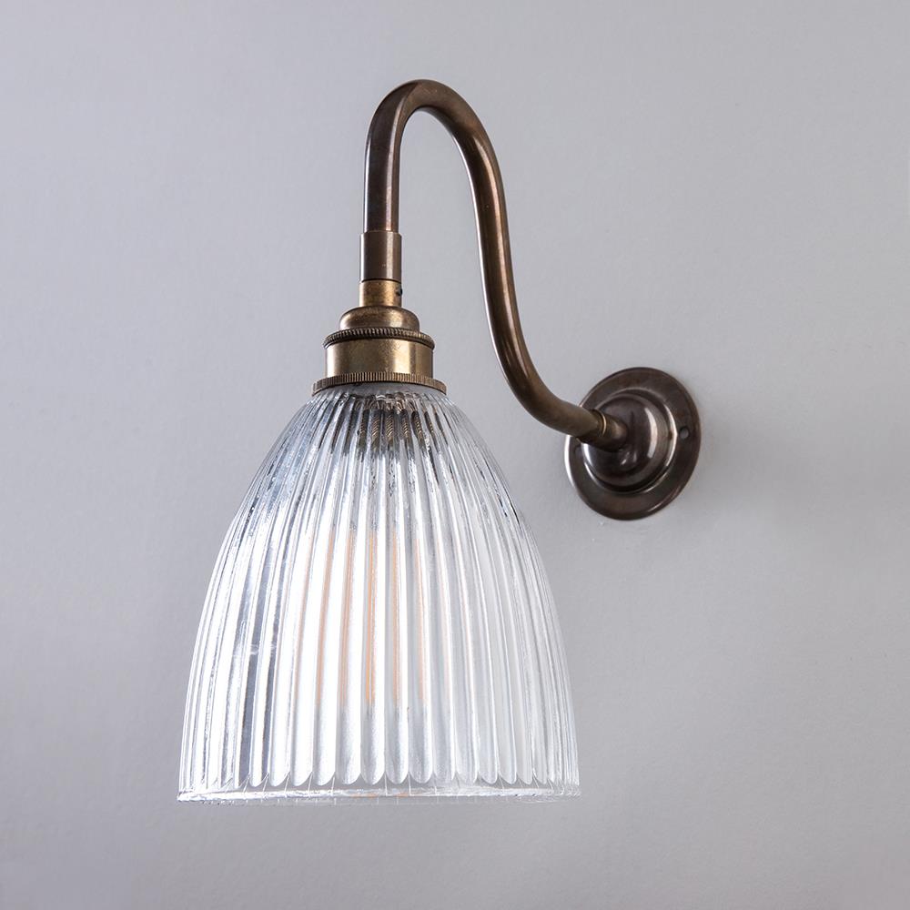 An Elongated Swan Arm Prismatic Bathroom Wall Light with a clear glass shade from Old School Electric.