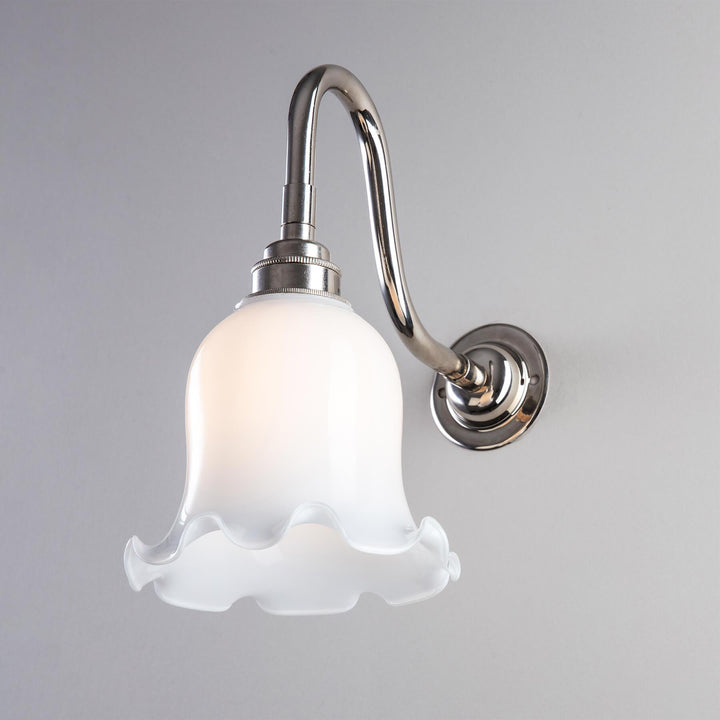 An Old School Electric Tulip Opal Glass Bathroom Wall Light fitting with a white glass shade.