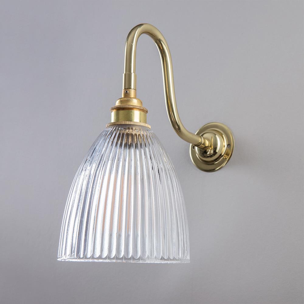 An Elongated Swan Arm Prismatic Bathroom Wall Light with a clear glass shade by Old School Electric.