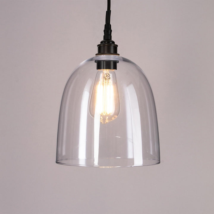 An Old School Electric Bell Blown Glass Bathroom Pendant Light with a black cord.