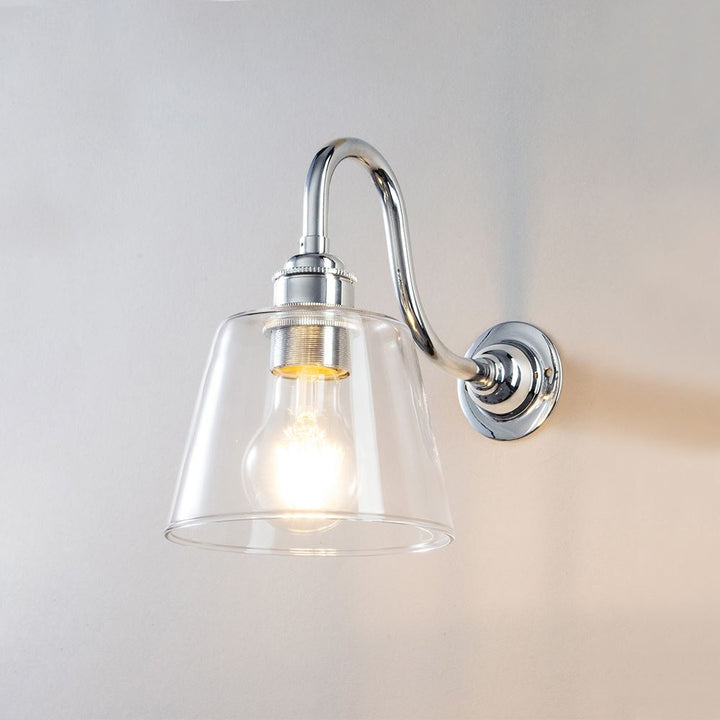 A Glass Swan Arm Wall Light by Old School Electric, perfect for illuminating any space. This sleek and contemporary lighting fixture adds a touch of elegance to any room. Pair it with other light fittings or use it.