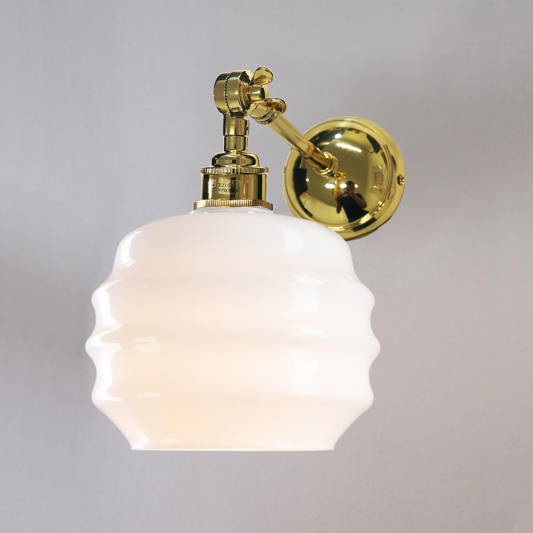 A Deco Opal Adjustable Arm Wall Light by Old School Electric adorns this brass wall light, creating a stunning light fitting.