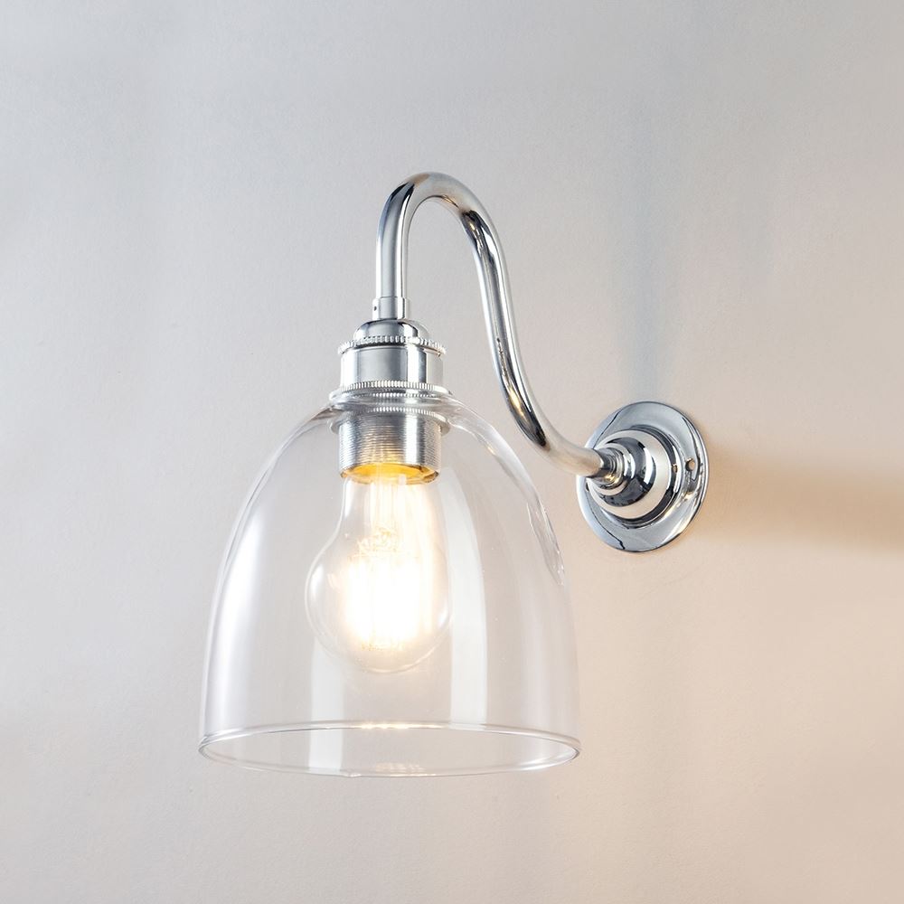 An Old School Electric Glass Swan Arm Wall Light with a clear glass shade, perfect for a modern and sleek light fitting.