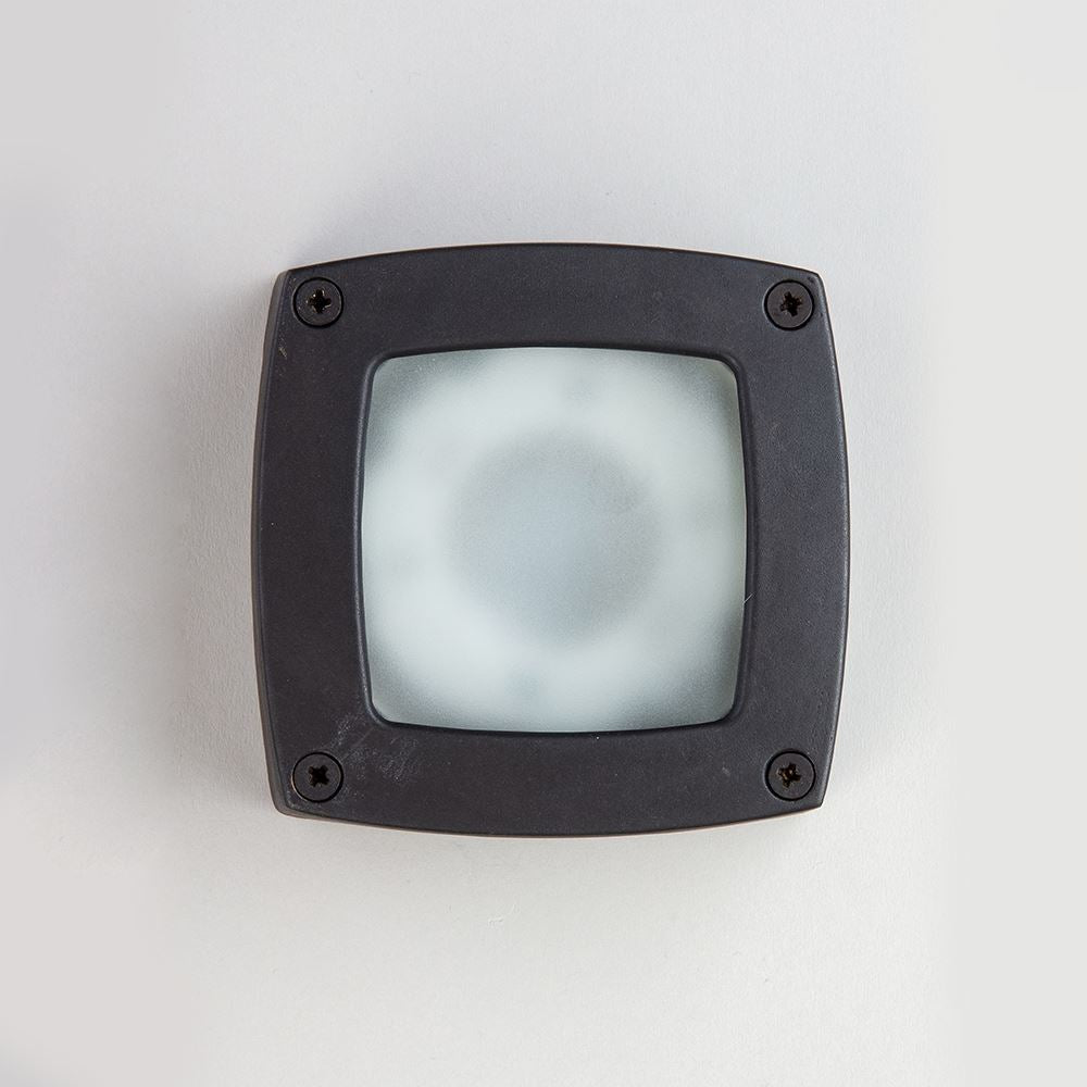 An Old School Electric black Square Outdoor Path Light on a white wall.