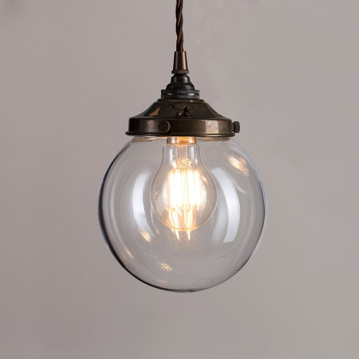 An Old School Electric brass chain hangs a Globe Blown Glass Pendant Light (B22), creating an elegant lighting fixture.