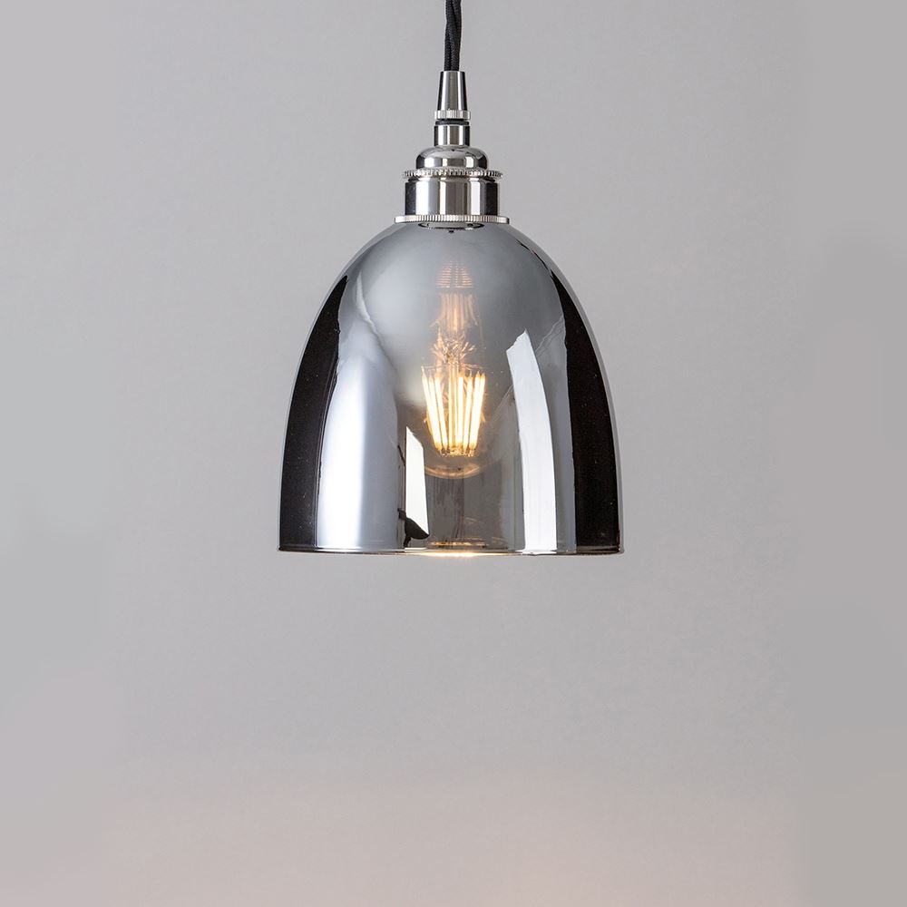 A Bell Blown Smoked Glass Pendant Light from Old School Electric hanging on a white wall.