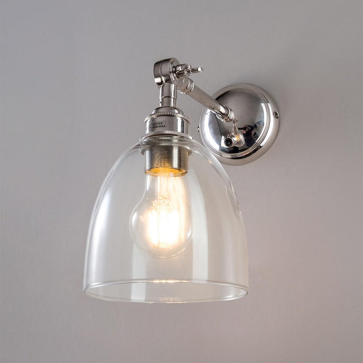 An Old School Electric Glass Adjustable Arm Wall Light with a clear glass shade.