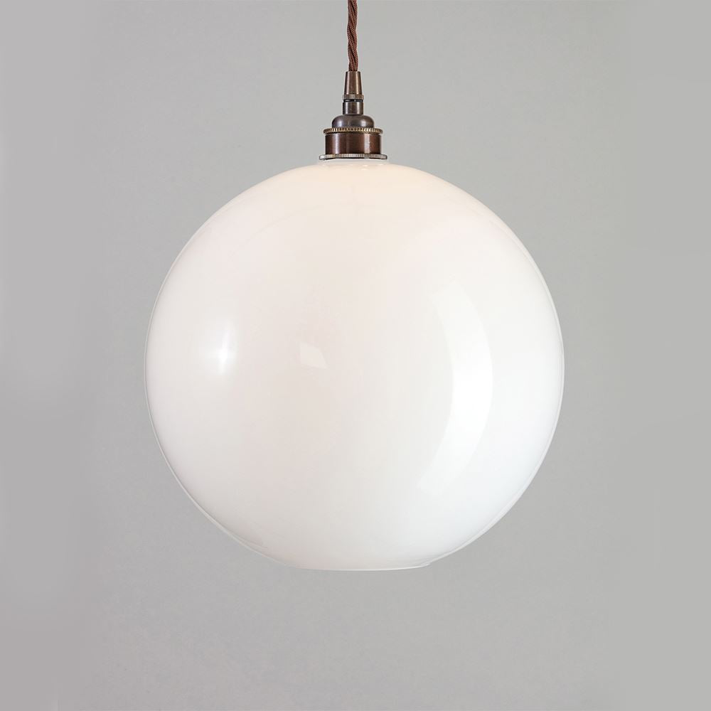 An Adderley Pendant Light by Old School Electric hanging from a ceiling. This light fitting adds a modern touch to any space with its elegant design and soft illumination.