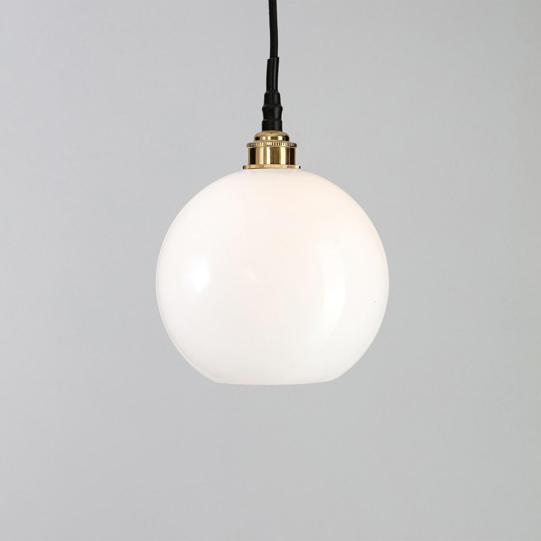 An Adderley Bathroom Pendant Light by Old School Electric with a white glass globe. The light fitting is stylish and modern, providing ample illumination with its electric lights. Perfect for illuminating any space, this pendant light adds a touch