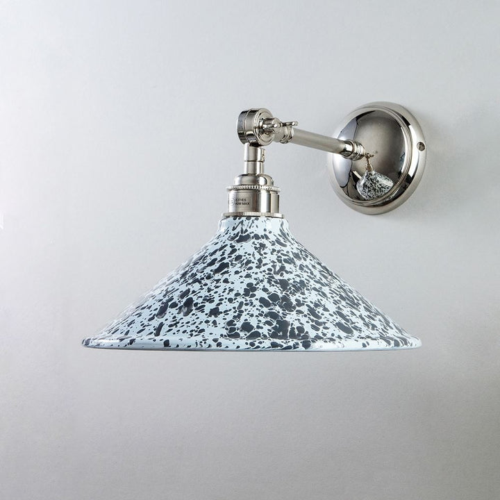 A Splatter Wear Shade Adjustable Arm Wall Light by Old School Electric with a blue speckled shade.