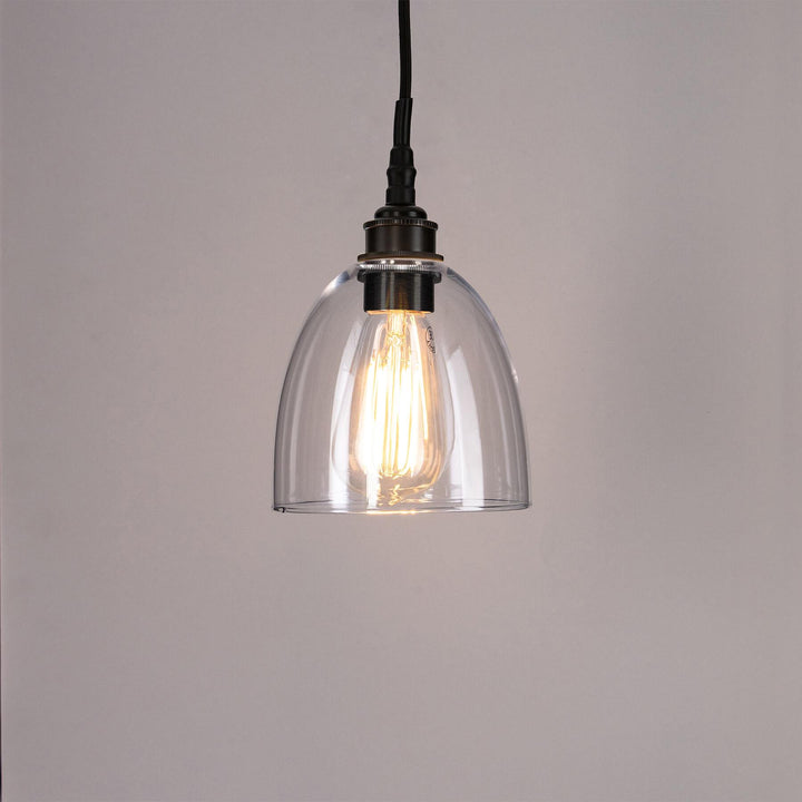 An Old School Electric Bell Blown Glass Bathroom Pendant Light hanging from a metal chain.