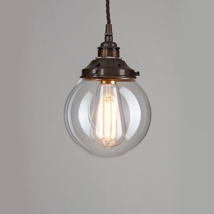 A Globe Blown Glass Pendant Light hanging from a metal chain, creating a stunning light fitting.