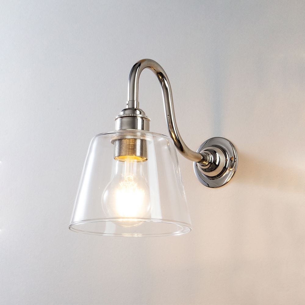 An Old School Electric Glass Swan Arm Wall Light fitting with a glass shade on a white wall.