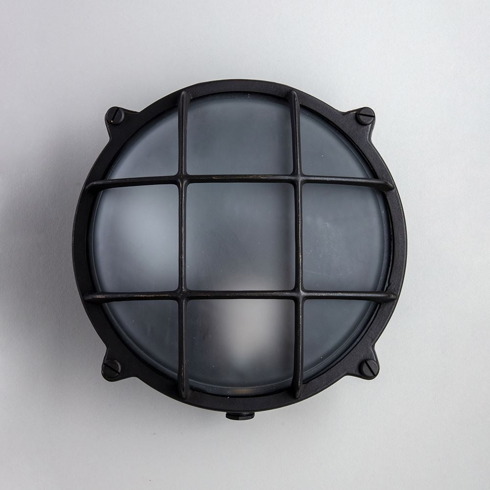 An Old School Electric Round Bulkhead Light with a metal grid.