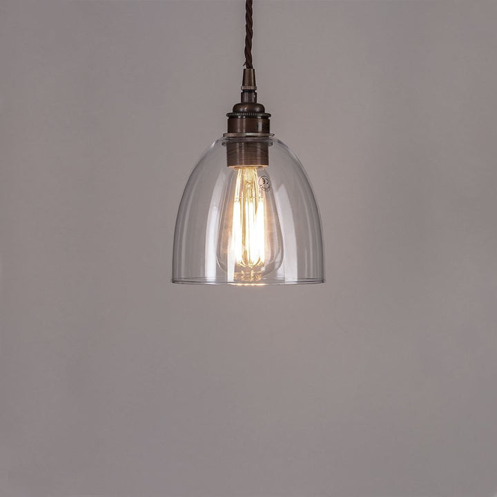 An Old School Electric Bell Blown Glass Pendant Light with a metal chain, perfect for adding elegance to any space. Expertly crafted, this light fitting effortlessly combines modern design with durability. Illuminate your space with the soft lighting provided by the Bell Blown Glass Pendant Light from Old School Electric.