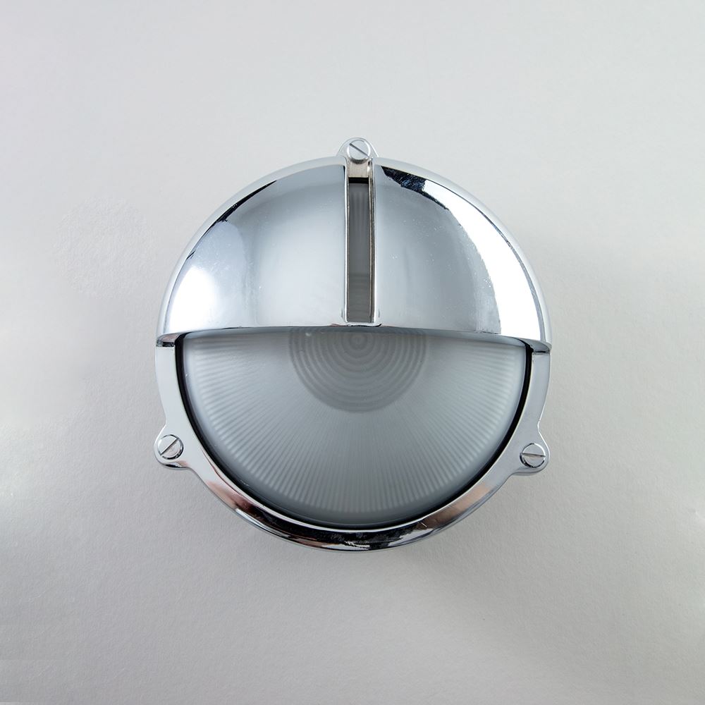 An Old School Electric Round Bulkhead With Eyelid Wall Light on a white wall.
