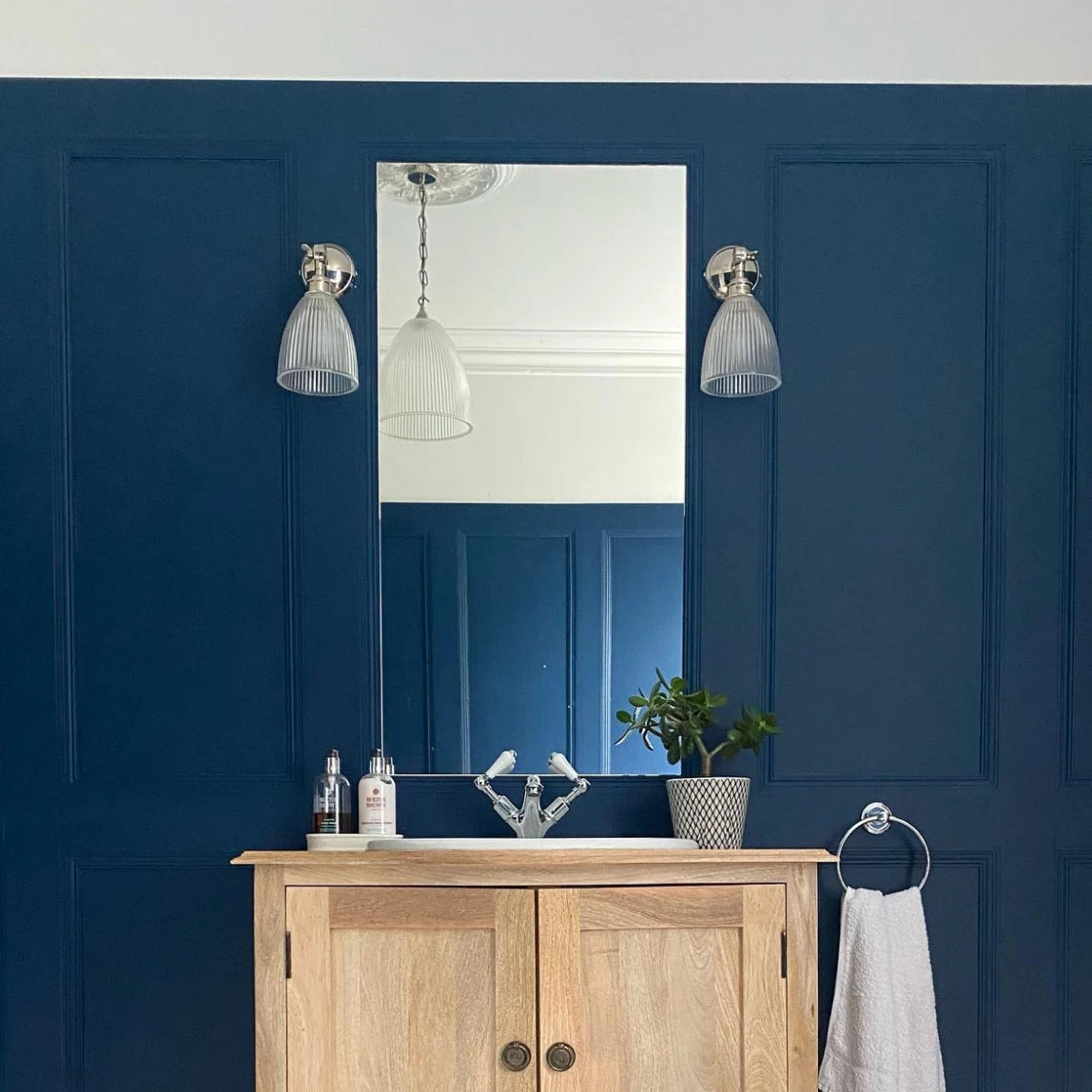 A bathroom with blue walls and a wooden vanity.